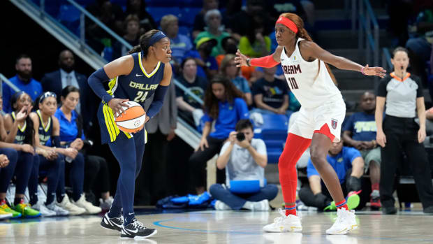 Wings guard Arike Ogunbowale tries to dribble past Atlanta's Rhyne Howard.